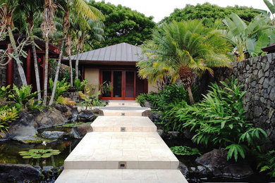 ハワイにある高級な広いトロピカルスタイルのおしゃれな中庭 (半日向、天然石敷き、池) の写真