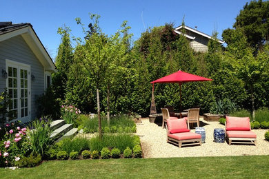 Modelo de jardín clásico de tamaño medio en patio trasero con jardín francés, exposición total al sol y gravilla