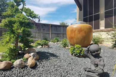 Imagen de camino de jardín asiático de tamaño medio en verano en patio delantero con jardín francés, exposición total al sol y adoquines de piedra natural