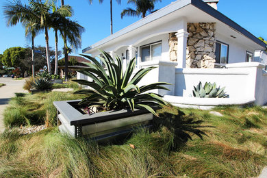 This is an example of a small modern drought-tolerant and partial sun front yard gravel landscaping in Los Angeles.