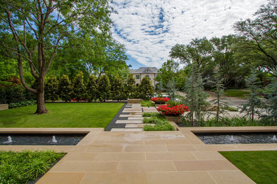 Medium sized contemporary front formal full sun garden for spring in Dallas with a water feature and natural stone paving.