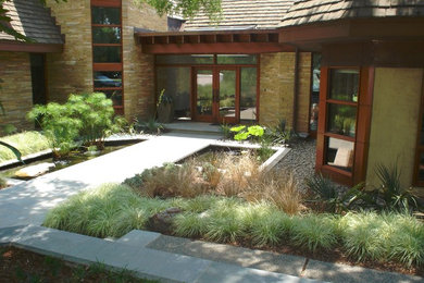 Ejemplo de jardín asiático de tamaño medio en patio delantero con estanque, exposición parcial al sol y adoquines de hormigón