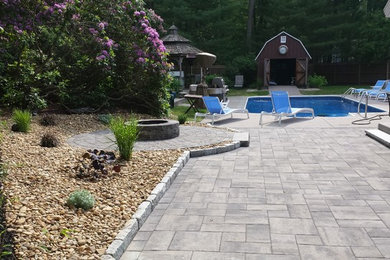 Inspiration for a mid-sized contemporary partial sun backyard concrete paver landscaping in Boston with a fire pit for summer.
