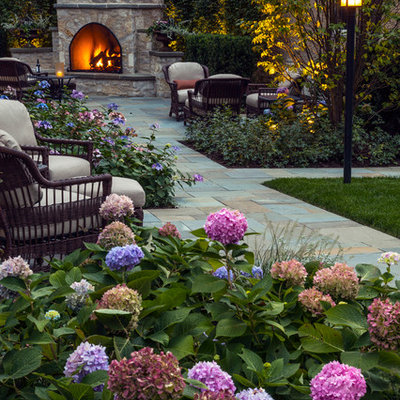 Design ideas for a large traditional partial sun backyard stone formal garden in Chicago with a fireplace.