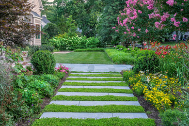 На фото: регулярный сад на переднем дворе в классическом стиле с садовой дорожкой или калиткой