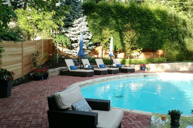 Photo of a large contemporary shade backyard brick landscaping in Kansas City for summer.