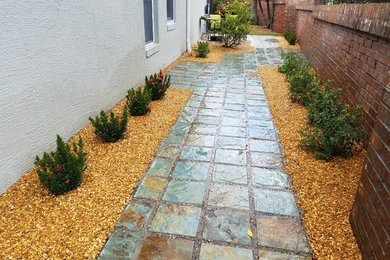 Inspiration for a small contemporary side full sun garden in Orlando with natural stone paving.