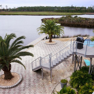 Inspiration for a coastal full sun backyard stone landscaping in New Orleans.