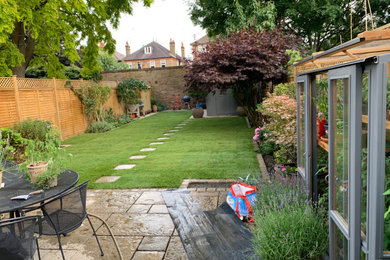 Photo of a large traditional privacy and full sun backyard concrete paver and wood fence formal garden for summer.