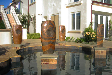 This is an example of a large modern back full sun garden in San Francisco with a water feature.