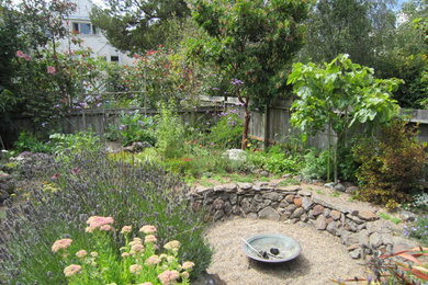 Photo of a mid-sized mediterranean full sun backyard gravel landscaping in San Francisco with a fire pit for fall.