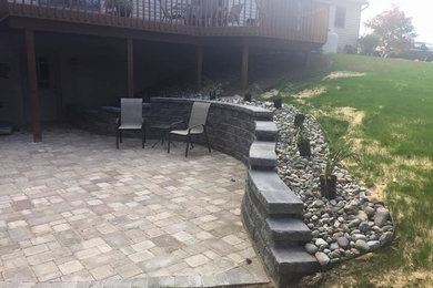 Photo of a mid-sized traditional backyard concrete paver retaining wall landscape in Philadelphia.