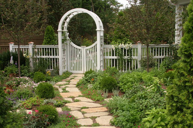 Immagine di un grande giardino classico esposto in pieno sole dietro casa con un ingresso o sentiero e pavimentazioni in pietra naturale