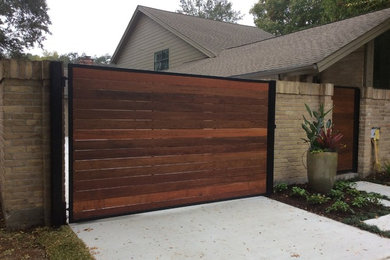 This is an example of a medium sized contemporary front driveway partial sun garden for spring in Houston with a garden path and concrete paving.