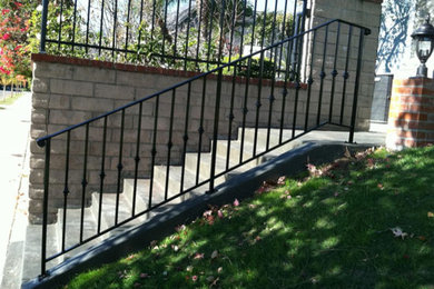 Photo of a small modern shade front yard concrete paver and metal fence driveway in Los Angeles for fall.