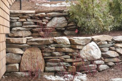 This is an example of a mid-sized traditional full sun mulch retaining wall landscape in Other.