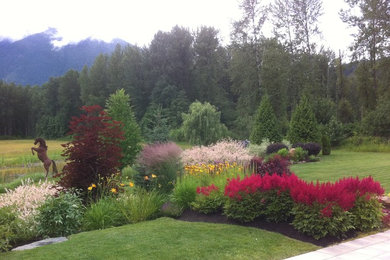 This is an example of a mid-sized farmhouse full sun backyard concrete paver landscaping in Vancouver for summer.