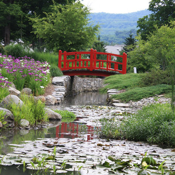 Japanese garden: stream with traditional red bridge