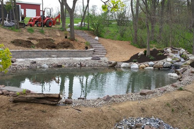 Photo of a huge modern partial sun hillside concrete paver pond in Philadelphia for spring.
