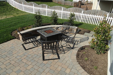 Design ideas for a mid-sized traditional full sun backyard brick landscaping in Baltimore with a fire pit.