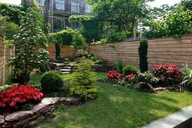 Photo of a mid-sized contemporary full sun backyard stone landscaping in New York.