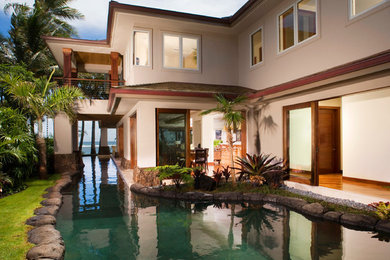 ハワイにあるラグジュアリーな広いトロピカルスタイルのおしゃれな庭 (日向、天然石敷き) の写真