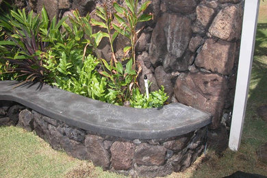 This is an example of a world-inspired back partial sun garden in Hawaii with natural stone paving.