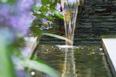 Modelo de jardín asiático pequeño en patio trasero con jardín francés, fuente y adoquines de piedra natural