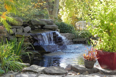 Imagen de jardín tradicional grande en patio trasero con jardín francés, estanque, exposición parcial al sol y adoquines de piedra natural