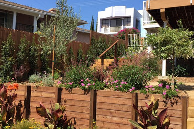 ロサンゼルスにあるラグジュアリーな広い、夏の地中海スタイルのおしゃれな庭 (擁壁、日向、デッキ材舗装、ウッドフェンス) の写真