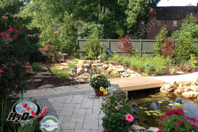 This is an example of a large traditional full sun backyard brick pond in Louisville.