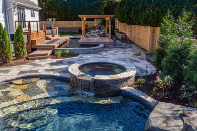 This is an example of a small transitional backyard stone pond in New York.