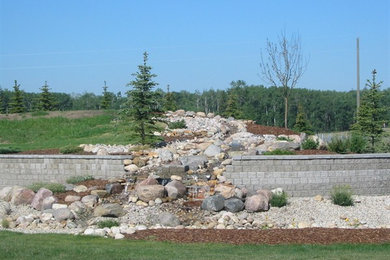 Photo of a large rustic backyard stone water fountain landscape in Calgary.