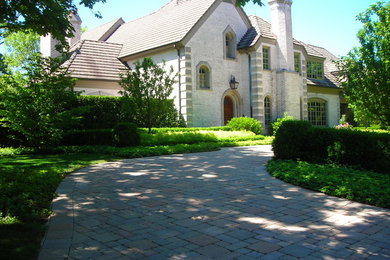 Design ideas for a large classic front driveway partial sun garden for summer in Chicago with brick paving.