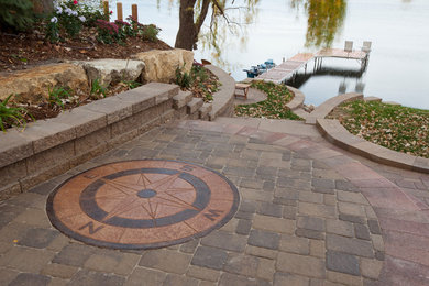 This is an example of a large rustic full sun backyard concrete paver landscaping in Minneapolis.