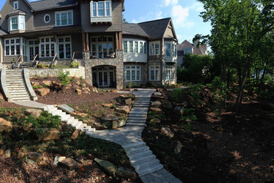Photo of a large rustic partial sun hillside concrete paver landscaping in Charlotte.