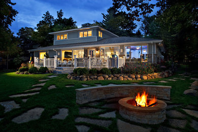 Photo of a large traditional backyard stone landscaping in Chicago with a fire pit.