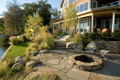 Photo of a large coastal full sun side yard stone landscaping in Boston with a fire pit.