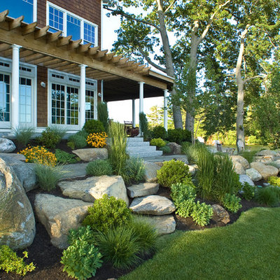 This is an example of a large coastal full sun and rock side yard stone landscaping in Boston.