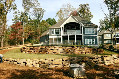 This is an example of a large traditional partial sun backyard retaining wall landscape in Other.