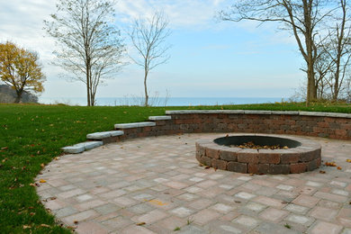 Photo of a traditional backyard brick landscaping in Other with a fire pit.