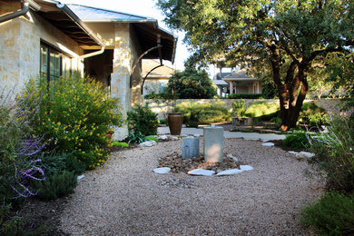 This is an example of a mid-sized mediterranean partial sun and drought-tolerant backyard gravel water fountain landscape in Austin for summer.