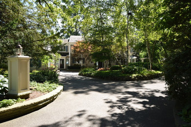 Exempel på en stor klassisk trädgård framför huset