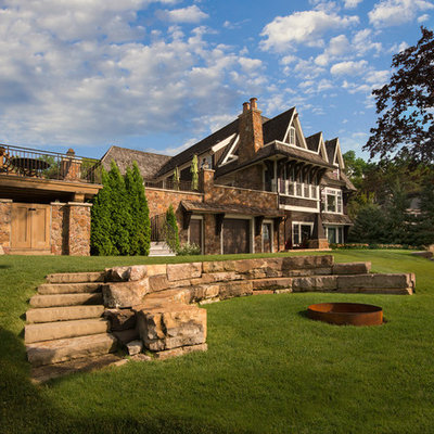 Inspiration for a huge traditional full sun backyard concrete paver landscaping in Minneapolis with a fire pit.