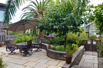 Ejemplo de jardín clásico de tamaño medio en verano en patio trasero con jardín francés, exposición parcial al sol y adoquines de piedra natural