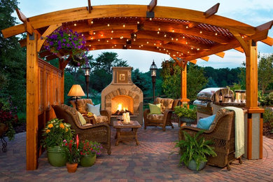 Large traditional back patio in Minneapolis with a fireplace and brick paving.
