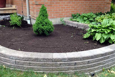 Inspiration for a large backyard stone landscaping in Toronto.