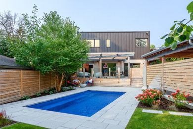 Design ideas for a modern partial sun backyard wood fence landscaping in Toronto with decking for summer.