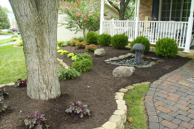 Inspiration for a large traditional front yard stone landscaping in DC Metro.