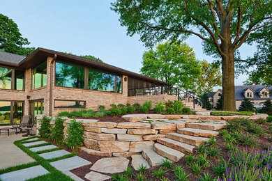 This is an example of a large traditional full sun backyard stone landscaping in Chicago.